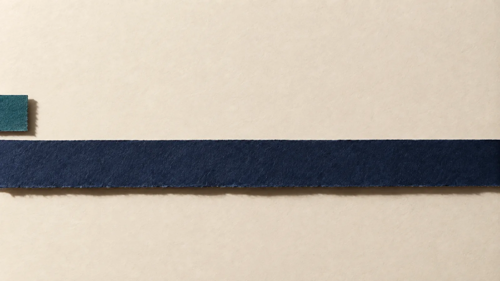 Papiercollage: ein sehr kurzer petrolfarbener Papierstreifen liegt ueber einem marineblauen Streifen, der ueber die gesamte Bildbreite und ueber den rechten Bildrand hinauslaeuft.